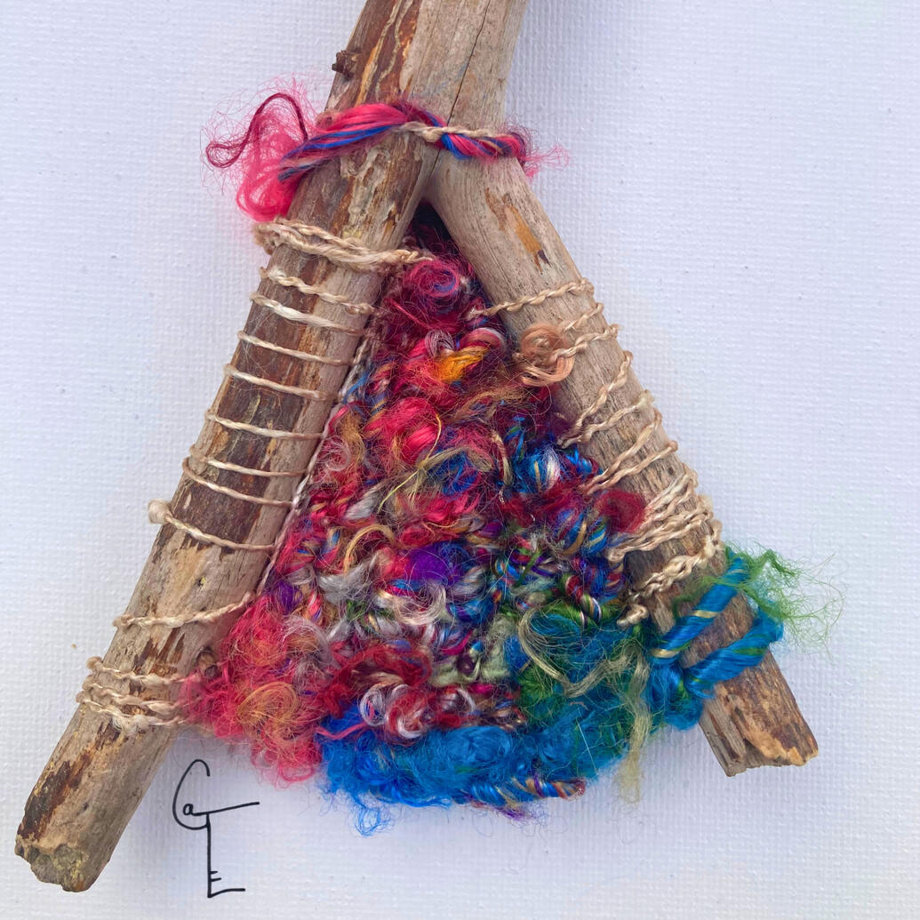 Fork shaped stick wound and knitted with handspun sari silk yarn inside the V shape.