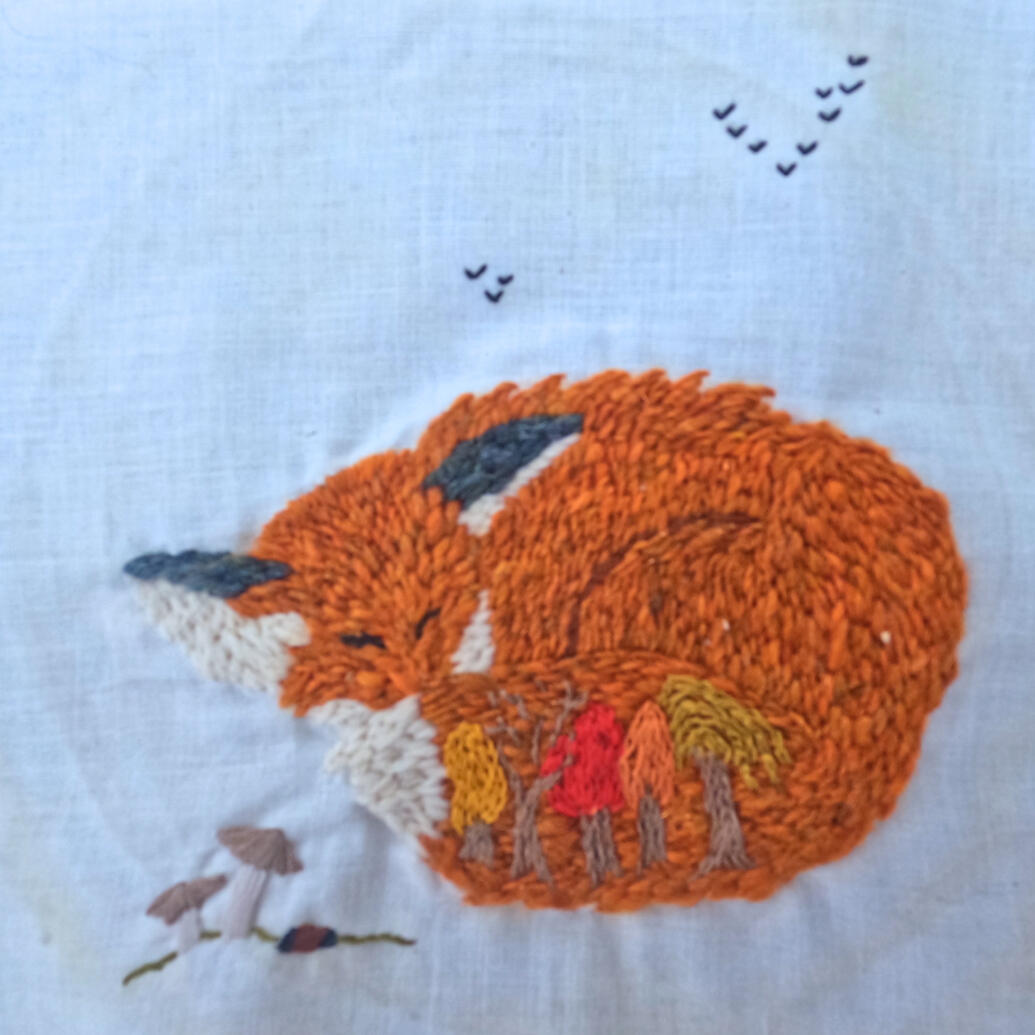 embroidered sleeping red fox with trees embroidered into tail on repurposed muslin